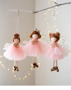 Detailed macro view of three pink mesh angel girl ornaments hanging on a decorative branch