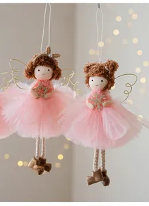 Close-up of angel girl ornaments with pink tutu and gold wings for Christmas tree.