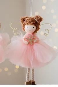 Close-up of pink tulle skirt angel girl Christmas ornament with gold snowflake
