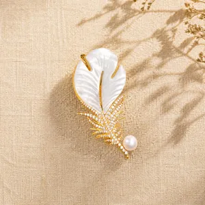 Close-up of elegant feather brooch with white mother-of-pearl and crystal accents