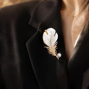 Elegant luxury mother-of-pearl feather brooch with diamonds and pearl on black blazer