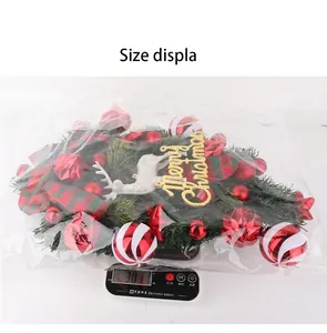 Gros plan d'une couronne de Noël pesée sur une balance, affichant un poids de 307,1g