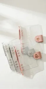 Detailed view of clear PVC 6-ring binder covers with colorful leather snap closures.