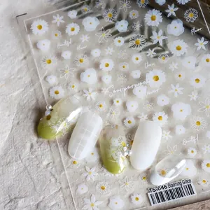 Close-up of white daisy nail stickers with 3D embossed floral patterns and nail art samples