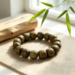 Detailansicht eines Armbands aus grünem Sandelholz auf einem neutralen Leinenhintergrund