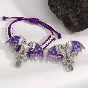 Detailed view of silver dragon jewelry with purple enamel wings and snowflake patterns