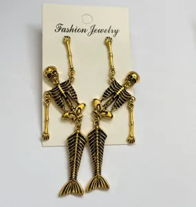 Close-up detail view of movable skeleton mermaid dangle earrings in antique gold finish