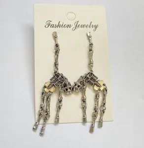 Detailed view of movable vintage silver gothic skeleton earrings on a white display card
