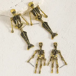 Detail view of golden skeleton and mermaid skeleton earrings for Halloween punk style.