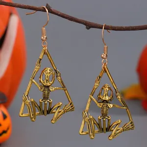Detailed shot of gold-finished gothic skeleton earrings with a punk hollow bone design.