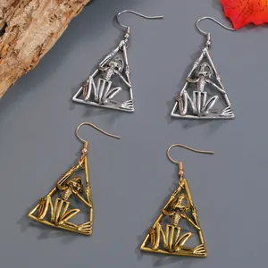 Macro view of gothic punk skeleton triangle earrings in gold and silver antique finishes