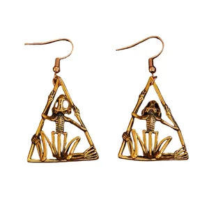 Detailed view of antique bronze Gothic skeleton drop earrings within hollow triangle frames