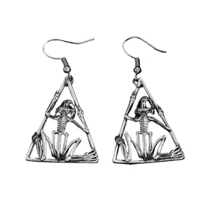 Close-up detail of gothic hollow skeleton frog earrings with a triangle metal frame