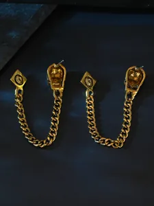 Detail view of golden gothic skull earrings with chain showing back construction.