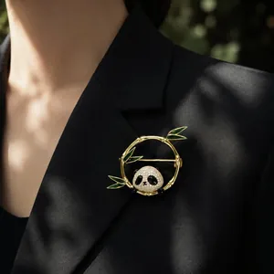 Close-up of a luxury panda and bamboo brooch with crystal details on a black suit