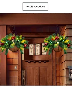 Two artificial Christmas hanging baskets with lights and ornaments decorating a wooden doorway