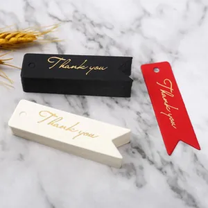 Dettaglio di etichette regalo a coda di rondine con scritta Thank You in lamina d'oro