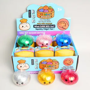 Assorted glitter bun squishy fidget toys in a colorful display box with mini steamers
