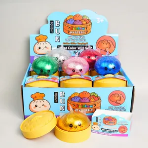 Full display set of colorful glitter baozi squishy toys in yellow steamers and blue box