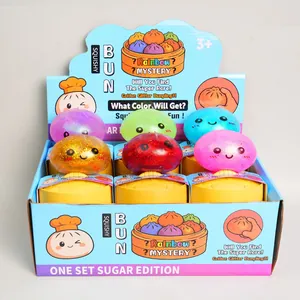 Detailed view of colorful glitter bun squishy toys in a display box with steamers.