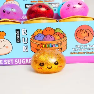 Detailed view of a golden glitter squishy bun toy with colorful packaging box background