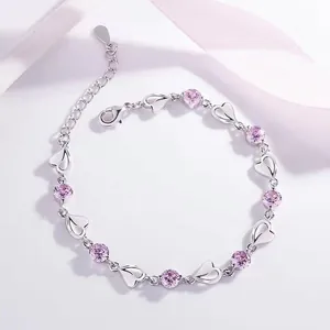 Vue détaillée d'un bracelet argenté avec maillons en cœur et pierres de zircon rose