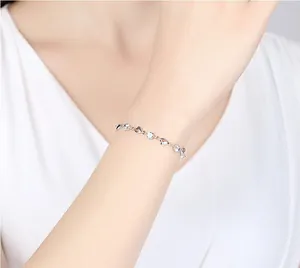 Gros plan d'un bracelet minimaliste plaqué argent avec des cœurs et des zircons