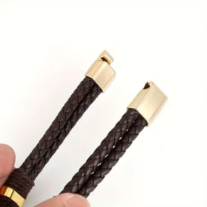 Close-up of golden metal clasps on a brown braided leather bracelet for men