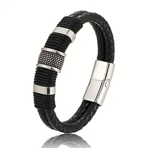 Primo piano di un bracciale in pelle nera intrecciata da uomo con chiusura in argento.