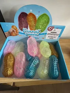 Gros plan de jouets à presser colorés en forme d'arachide avec paillettes en boîte