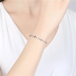 Bracelet cœur en argent avec cristaux bleus et zircons au poignet d'un mannequin