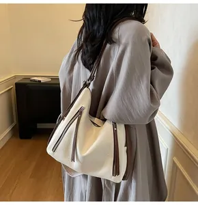 Détail d'un grand sac fourre-tout blanc avec de larges bretelles marron sur modèle