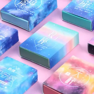 Detailed macro shot of zodiac themed mini notebook boxes with colorful starry sky design