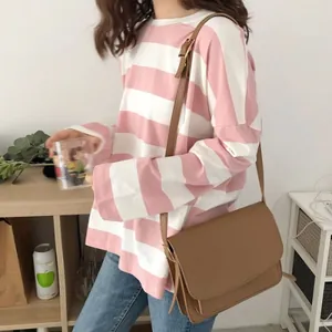 Detailweergave van een roze en wit gestreept T-shirt met lange mouwen voor dames, ruimvallend