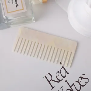 Detail of pearlescent acetate hair comb with wide teeth and elegant marble pattern