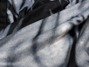 Macro detail view of black and white witch costume fabric with flame halftone print pattern