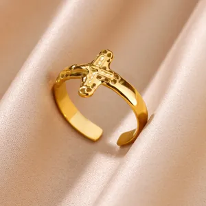 Detailed view of the textured cross motif on an 18K gold plated stainless steel open ring