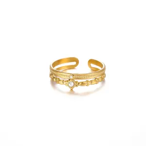 Close-up detail of a minimalist gold double-layered open ring with sparkly clear stones