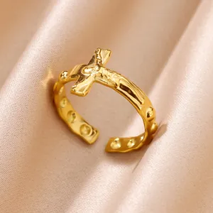 Close-up of 18K gold plated stainless steel open ring with a religious cross design