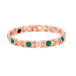 Close-up of rose gold magnetic bracelet with green stones and rhinestones