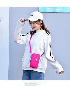 Asiatisches Modell zeigt rosa vertikale Mini-Umhängetasche für Handys mit Herz-Reißverschluss
