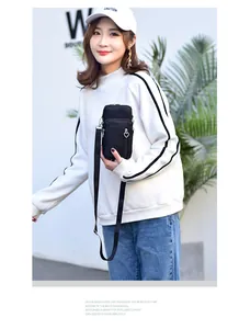 Modell mit schwarzer Mini-Handytasche im Hochformat mit dreilagigem Reißverschluss-Design