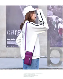 Asiatisches Model zeigt eine lila Nylon-Mini-Umhängetasche für Handys im urbanen Stil