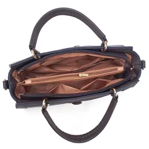 Innenansicht einer stilvollen braunen Handtasche mit Innenfutter und goldenen Reißverschlüssen.