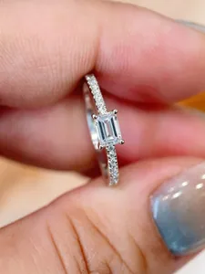 Dettaglio ravvicinato di un anello con diamante taglio smeraldo e fascia pavé.