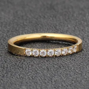 Close-up of a minimalist 2mm gold plated stainless steel ring with single row of inlaid stones