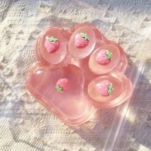 Detailed view of translucent pink cat paw squishy toy with cute embedded strawberries