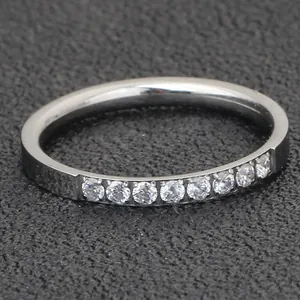 Macro detail of minimalist 2mm stainless steel ring with single row of clear stones.