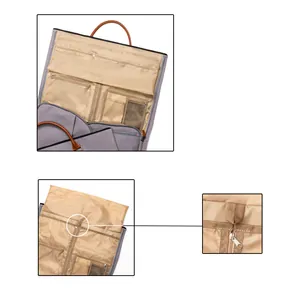 Detailansicht der hellbraunen Innenfächer und Reißverschlüsse einer grauen Kleidertasche.