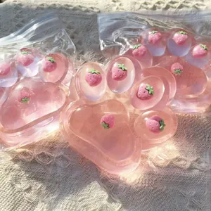 Close-up view of a translucent pink strawberry cat paw squishy stress relief toy